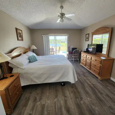 a bedroom with a bed and a dresser and a television at Lake Berkley Home #213517 in Kissimmee