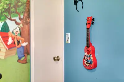 a red guitar hanging on a blue wall at Family Vacation Villa, Water Park, Endless Amenities in Kissimmee