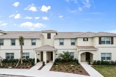 a large white house with a palm tree at Four Bedrooms w/ Pool TownHome 4841 in Kissimmee