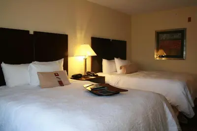 a hotel room with two beds with a tray on it at Hampton Inn & Suites Orlando-John Young Parkway/South Park in Orlando