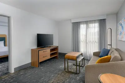 a hotel room with a couch and a tv at Homewood Suites by Hilton Orlando-UCF Area in Orlando