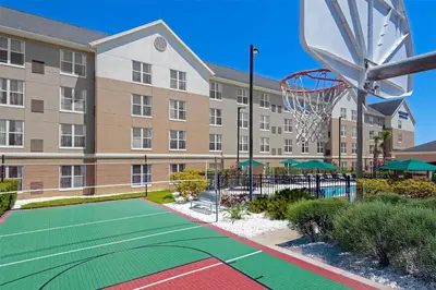 an apartment building with a basketball court and a basketball hoop at Homewood Suites by Hilton Orlando-UCF Area in Orlando