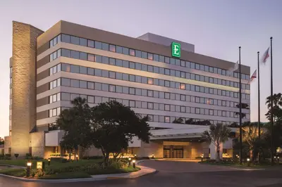 a large building with a green sign on it at Embassy Suites by Hilton Orlando International Drive ICON Park in Orlando