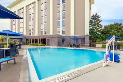a large swimming pool in front of a hotel at Hampton Inn Orlando-International Airport in Orlando