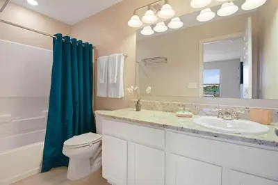a bathroom with a sink and a toilet and a mirror at Four Bedrooms TownHome 5130 in Kissimmee