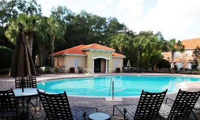 a swimming pool with chairs and an umbrella at Four Bedrooms TownHome 5130 in Kissimmee