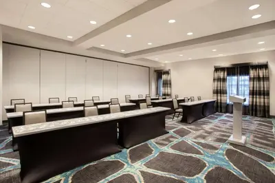 a conference room with chairs and a large projection screen at Embassy Suites by Hilton Orlando Airport in Orlando