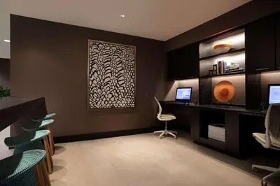 a office with a desk and a computer on a wall at Embassy Suites by Hilton Orlando Airport in Orlando