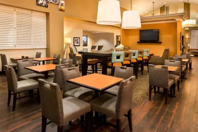 a restaurant with tables and chairs and a television at Hampton Inn & Suites Orlando-East UCF in Orlando