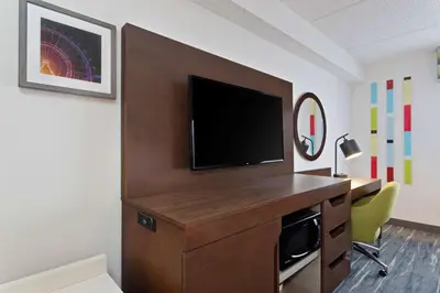 a hotel room with a tv and a desk with a desk at Hampton Inn & Suites Orlando International Drive North in Orlando