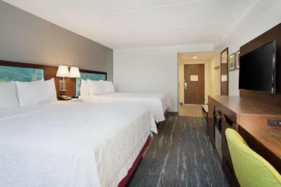 a hotel room with two beds and a flat screen tv at Hampton Inn & Suites Orlando International Drive North in Orlando