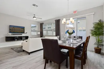 a dining room and living room with a table and a couch at Four Bedrooms Resort TownHome 5128 in Kissimmee