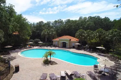 an overhead view of a swimming pool with chairs and trees at Four Bedrooms Resort TownHome 5128 in Kissimmee