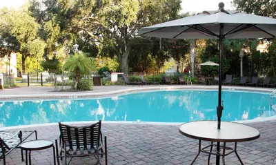 a table with an umbrella next to a pool at Four Bedrooms Resort TownHome 5128 in Kissimmee