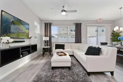 a living room with a white couch and a tv at Four Bedrooms Resort TownHome 5128 in Kissimmee