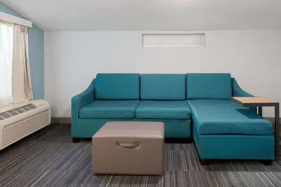 a living room with a blue couch and a ottoman at Hampton Inn Orlando Near Universal Blv/International Dr in Orlando