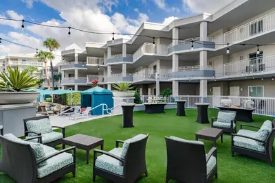 a large apartment patio with chairs and tables at Embassy Suites by Hilton Orlando Lake Buena Vista Resort in Orlando