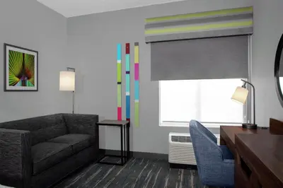 a living room with a couch and a chair and a window at Hampton Inn Lake Buena Vista / Orlando in Orlando