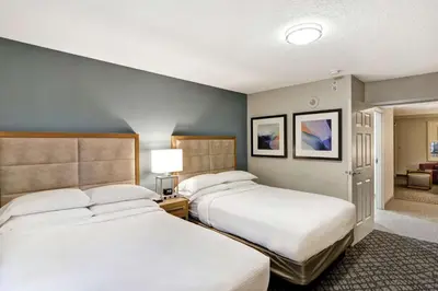 a hotel room with two beds and a hallway at Embassy Suites by Hilton Orlando Downtown in Orlando