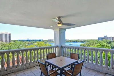 a table and chairs on a balcony with a ceiling fan at Embassy Suites by Hilton Orlando Downtown in Orlando