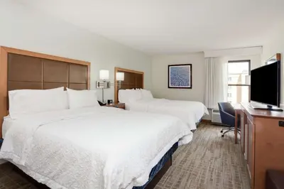 a hotel room with two beds and a flat screen tv at Hampton Inn Orlando International Drive Convention Center in Orlando