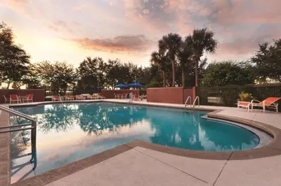 a swimming pool at a resort with a sunset at Hampton Inn Orlando International Drive Convention Center in Orlando