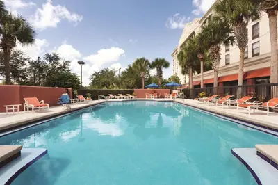 a large swimming pool with chairs and a building at Hampton Inn Orlando International Drive Convention Center in Orlando