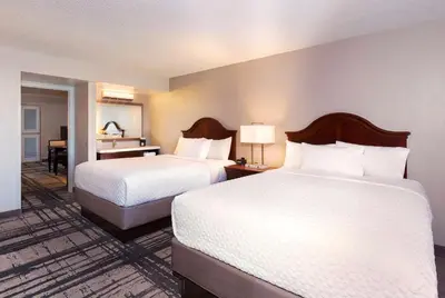a hotel room with two beds and a desk at Embassy Suites by Hilton Orlando International Drive Convention Center in Orlando