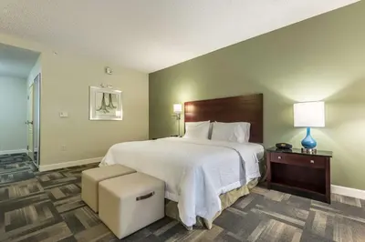a bedroom with a large bed with a white bedspread at Hampton Inn & Suites Orlando-South Lake Buena Vista in Kissimmee