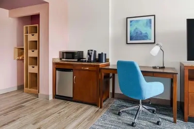 a room with a desk and a blue chair at Hilton Garden Inn Orlando at SeaWorld in Orlando