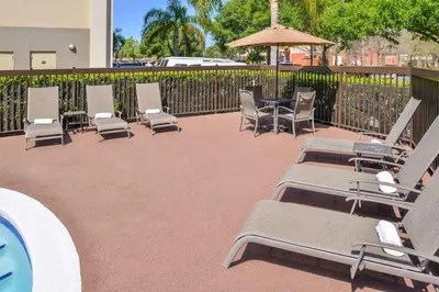 a patio with chairs and a table and umbrella at Hampton Inn Closest to Universal Orlando in Orlando