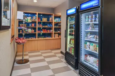 a room with a refrigerator and shelves of food at Hampton Inn Closest to Universal Orlando in Orlando