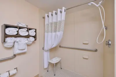 a bathroom with a shower and a toilet and towels at Hampton Inn Closest to Universal Orlando in Orlando