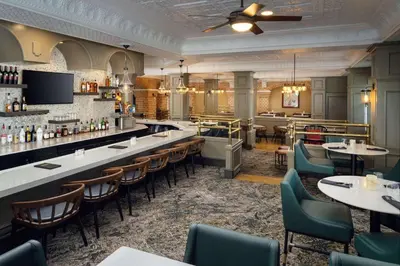 a restaurant with a bar and tables and chairs at Embassy Suites by Hilton Orlando North in Orlando