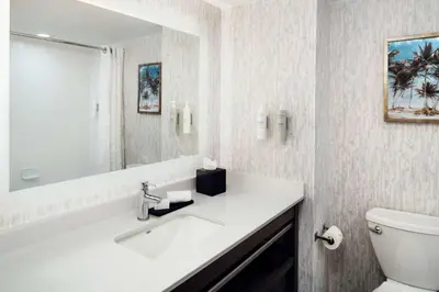 a bathroom with a sink and a toilet and a mirror at Embassy Suites by Hilton Orlando North in Orlando