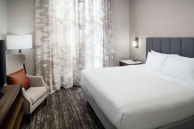a hotel room with a bed and a chair at Embassy Suites by Hilton Orlando North in Orlando