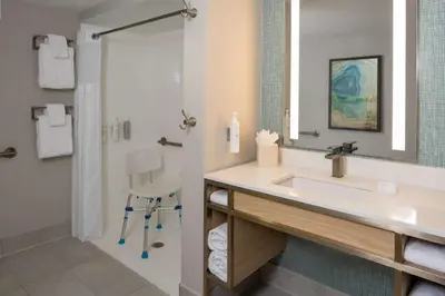 a bathroom with a sink and a shower at Hilton Garden Inn Orlando Airport in Orlando