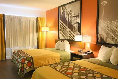 a hotel room with two beds with orange walls at Orlando Inn International Drive Area in Orlando