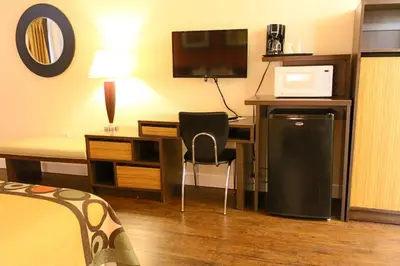 a hotel room with a desk with a computer and a bed at Orlando Inn International Drive Area in Orlando