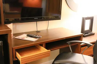 a desk with a television and a chair in a room at Orlando Inn International Drive Area in Orlando