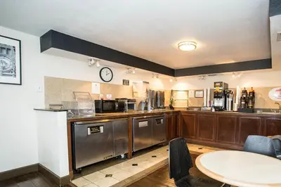 a kitchen with wooden cabinets and a clock on the wall at Orlando Inn International Drive Area in Orlando