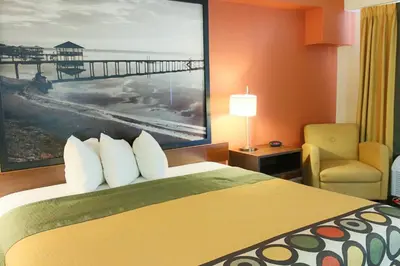 a hotel room with a bed and a chair at Orlando Inn International Drive Area in Orlando