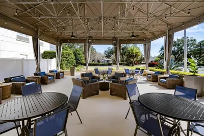 an outdoor patio with tables and chairs and tablesktop at Hilton Garden Inn Lake Mary in Lake Mary
