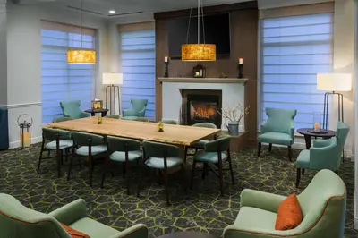 a dining room with a table and chairs and a fireplace at Hilton Garden Inn Lake Mary in Lake Mary