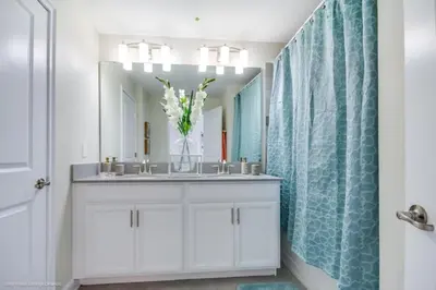 a bathroom with a sink with a vase of flowers at Romeo Circle #239854 Townhouse in Kissimmee