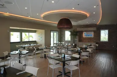 a dining room with tables and white chairs at Disney Dreams Luxury Home with Private Water Park in Orlando