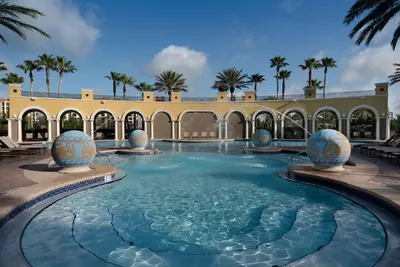 a swimming pool in a building with palm trees at Hilton Grand Vacations Club Tuscany Village Orlando in Orlando