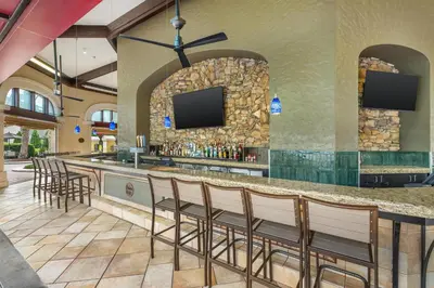 a bar in a resort with chairs and a tv at Hilton Grand Vacations Club Tuscany Village Orlando in Orlando