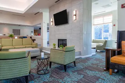 a lobby with couches and chairs and a fireplace at Hilton Garden Inn Orlando East - UCF Area in Orlando