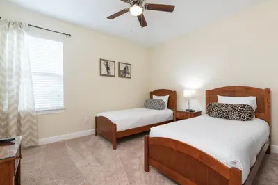 a bedroom with two beds and a ceiling fan at Luxury Dreams Disney Home with Private Pool and Spa in Orlando